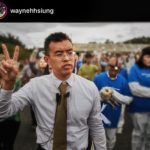 Wayne holds up his right hand making a “peace” sign, as he walks along with 600 animal advocates while they openly rescue dying chickens from factory farming conditions